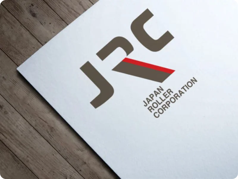 木製のデスクに置かれたJRCのロゴ入り会社案内